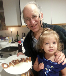 Larry displaying a plate with 'Darwin' spelled out in letter-shaped pancakes