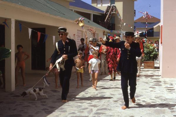 The parade marches through the village streets